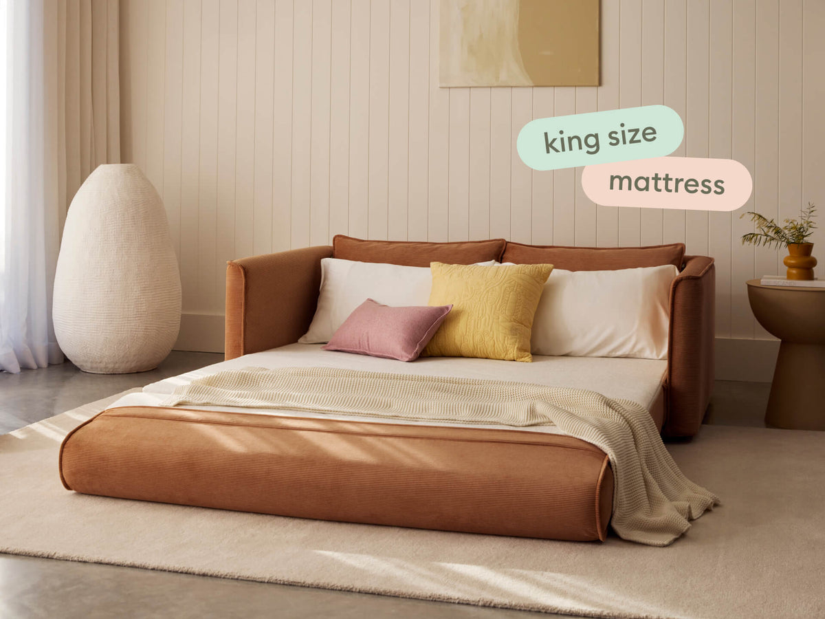 Koala Sofa Bed 4th Gen 3-Seater in Sandstone, flipped out and made up as a king-size bed in a bedroom